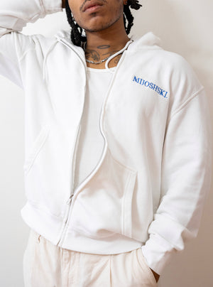 Person wearing a white hoodie with 'Mijoshski' branding on a plain background